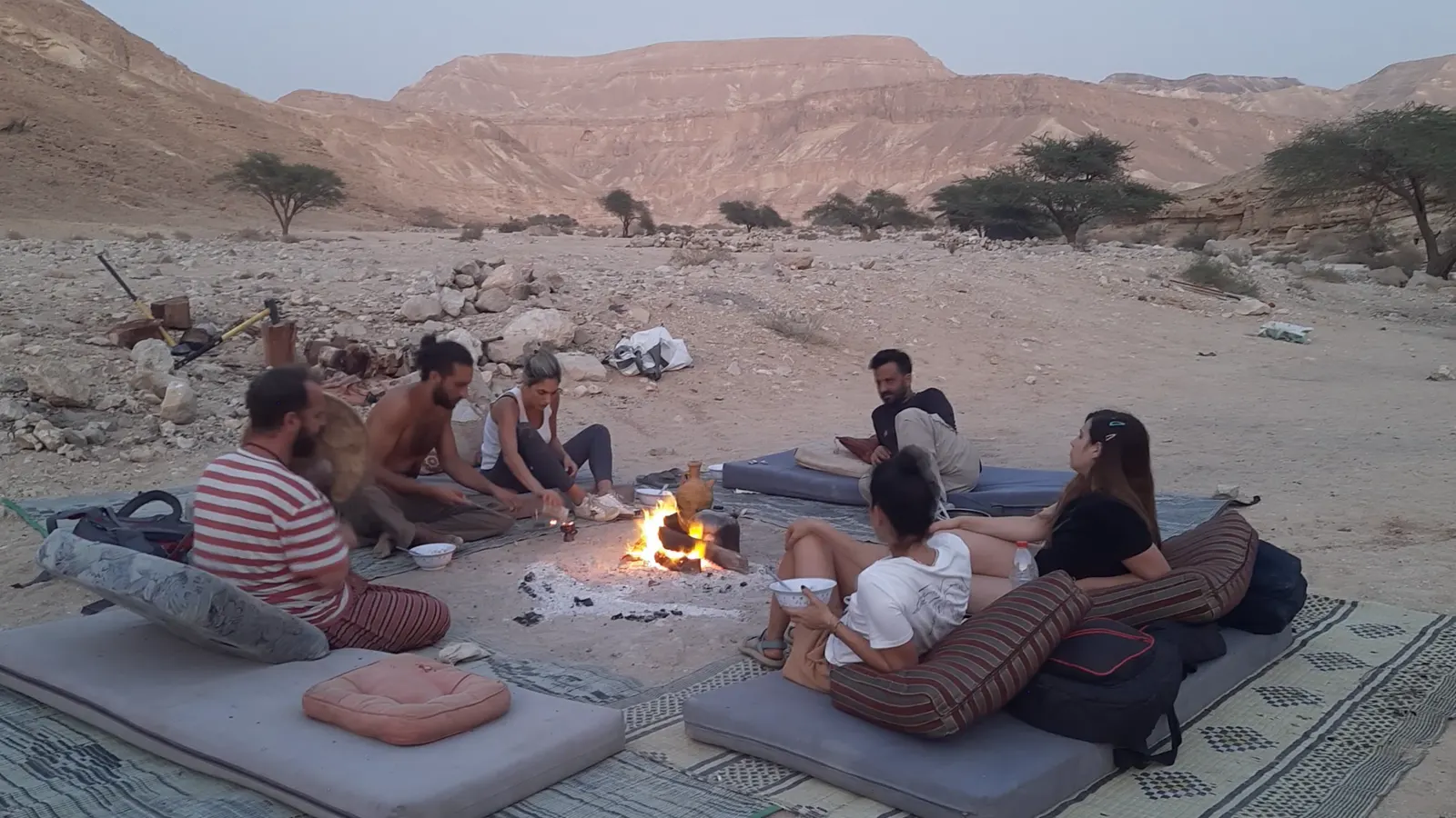 מעגל משתתפים יושבים על מזרונים במדבר